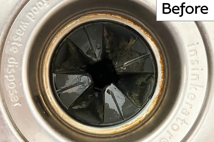 Kitchen sink garbage disposal drain with rubber splash guard that has brown discoloration on the rubber and on the inner metal ring and is labeled 'Before'.