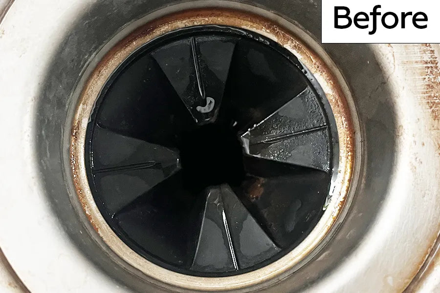 Kitchen sink garbage disposal drain with rubber splash guard that has rust and debris and is labeled 'Before'.