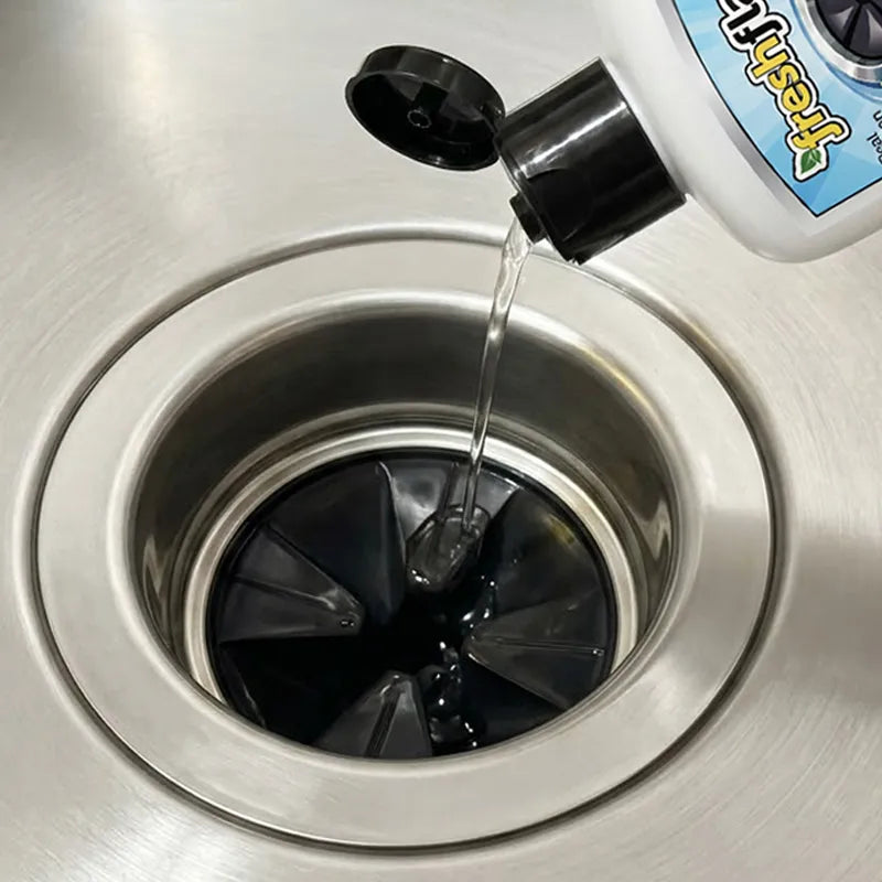 FreshFlap cleaning solution being poured onto the rubber disposal flap in the sink 
